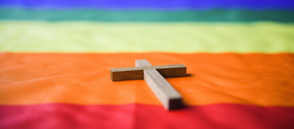 Kreuz auf Regenbogenfahne
