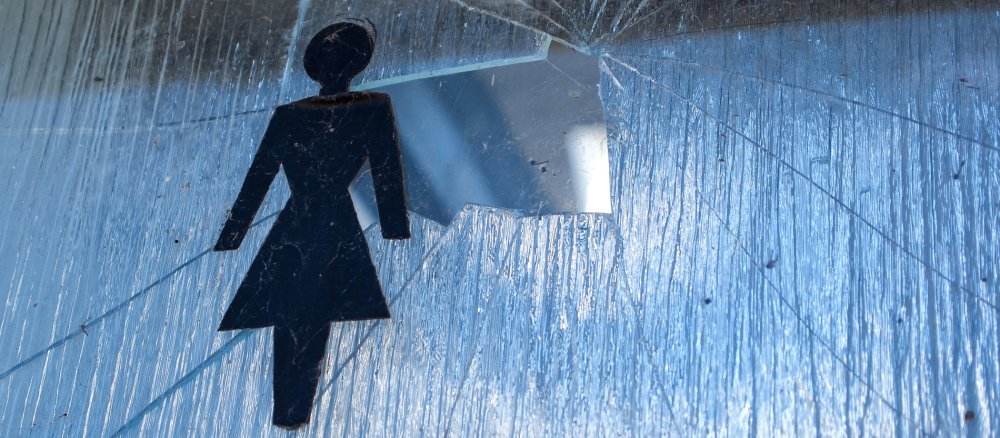 Im eingeschlagenen Milchglasfenster einer Frauentoilette fehlt ein großes Stück Glas
