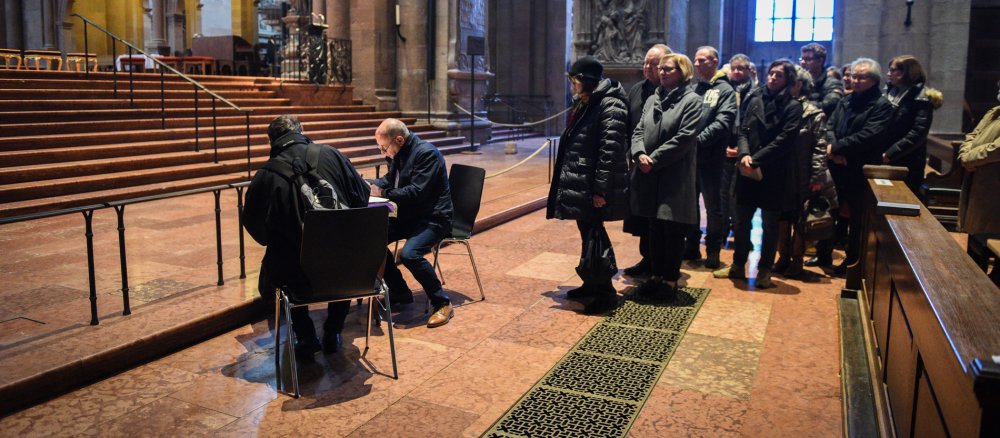 Zwei Männer tragen sich im Mainzer Dom in Kondolenzlisten für den verstorbenen Mainzer Bischof Kardinal Karl Lehmann ein.