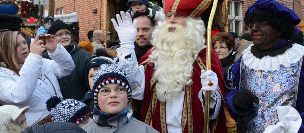 Neben ihm steh der Zwarte Piet.