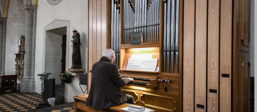 Ein Organist spielt Orgel in einer Kirche