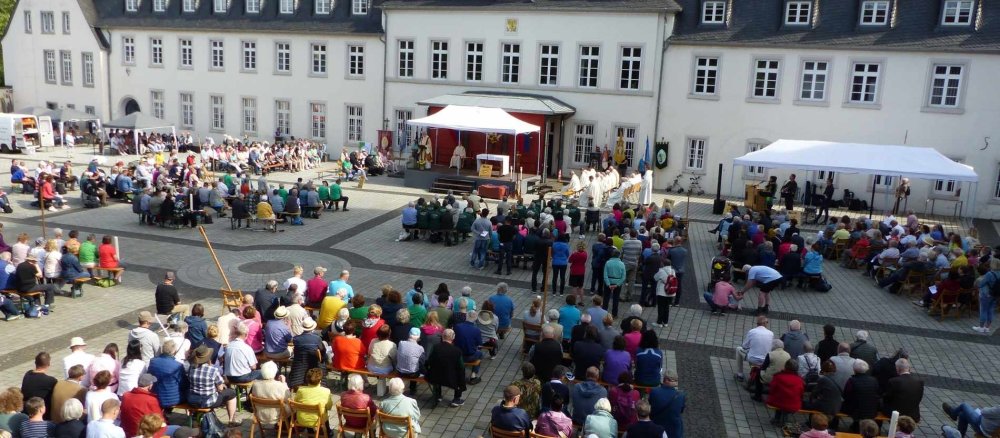 Viele Pilger treffen sich für einen Gottesdienst unter freiem Himmel.