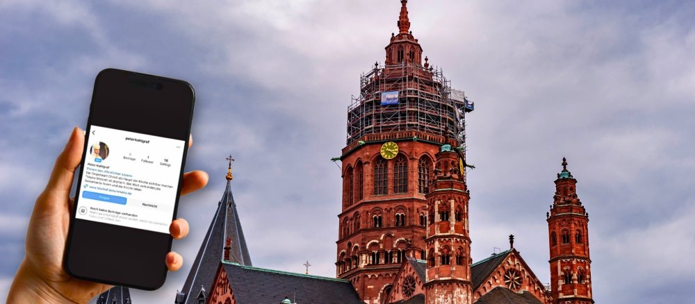 Handy mit Instagram-Warnung des Bistums Mainz vor dem Mainzer Dom