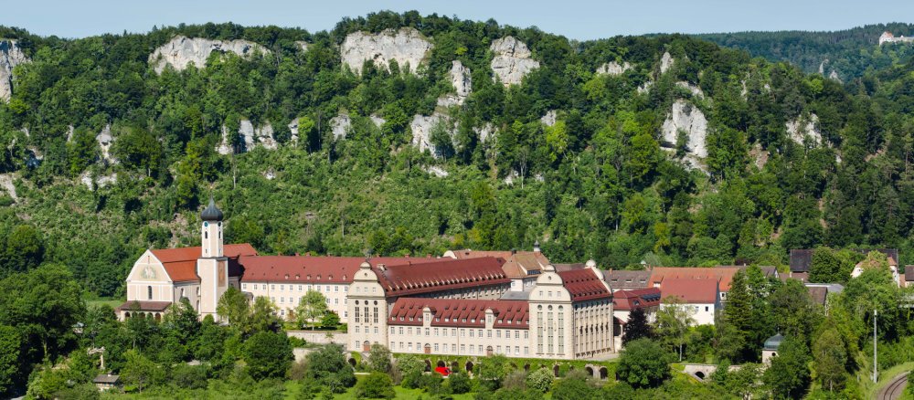 Die Erzabtei St. Martin in Beuron liegt malerisch vor Bergen.