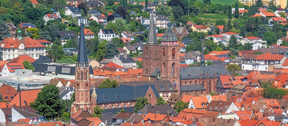 Blick über Neustadt an der Weinstraße: Im Vordergrund der Turm der katholischen Kirche St. Marien; im HIntergrund die beiden Türme der Stiftskirche