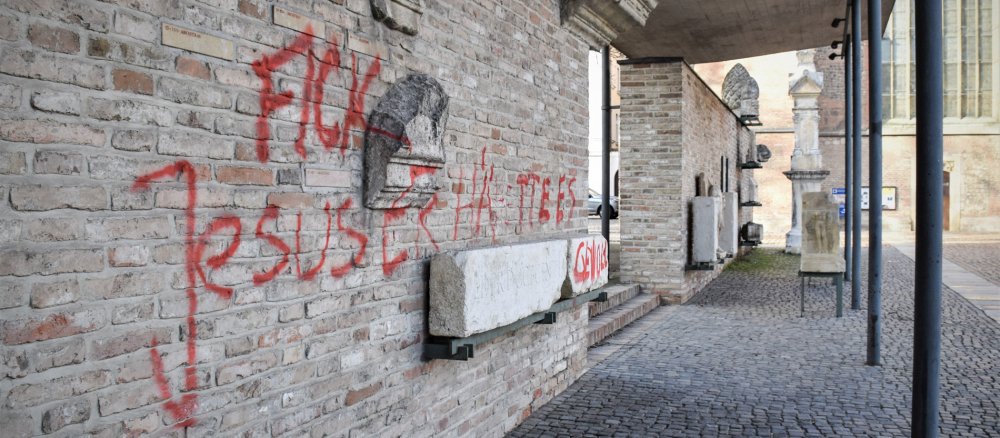 Schriftzug "Fick Jesus! Er hätte es gewollt!" an einer Wand vor dem Augsburger Dom