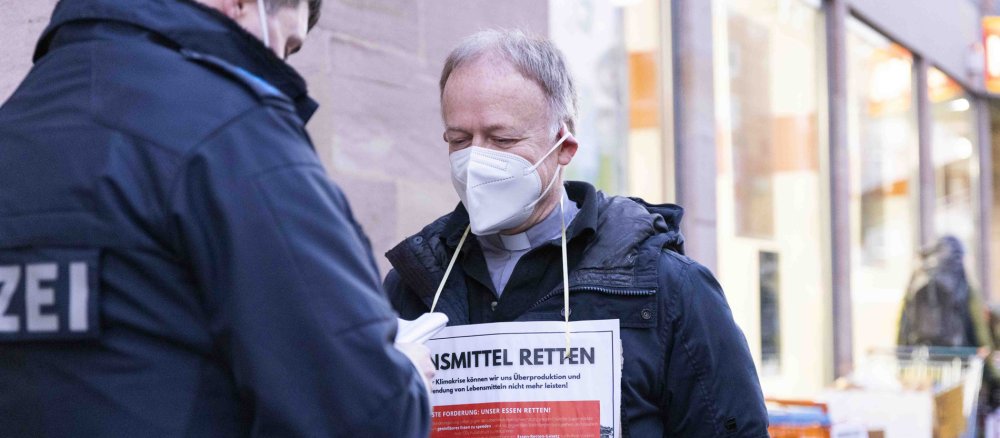 Jesuitenpater Jörg Alt unterhält sich mit Polizisten in der Nürnberger Innenstadt