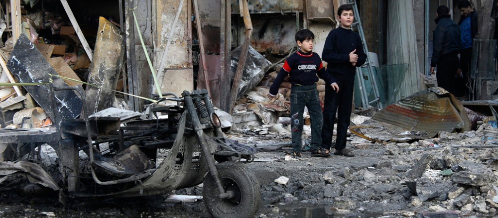 Kinder stehen am 1. Januar 2014 vor einem zerstörten Haus in Aleppo, das nach Angaben der Rebellengruppen durch den Beschuß von Reierungstruppen zerstört worden ist.