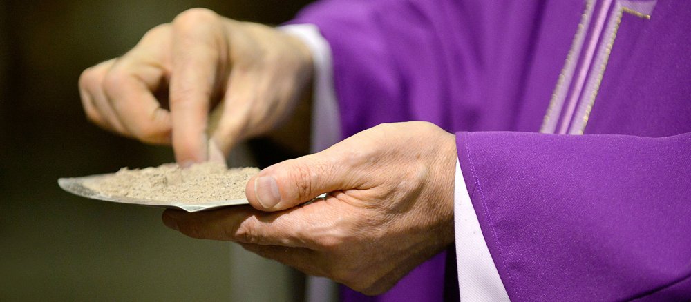 Ein Priester mit einer Schale voller Asche