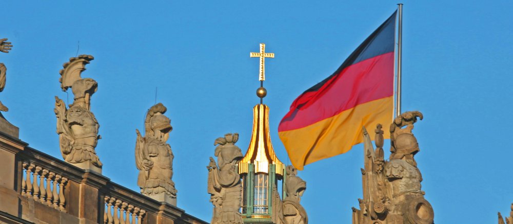 Ein Kreuz und eine Deutschland-Flagge.