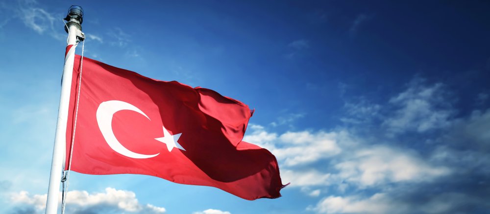 Die türkische Flagge weht vor einem bewölkten Himmel.