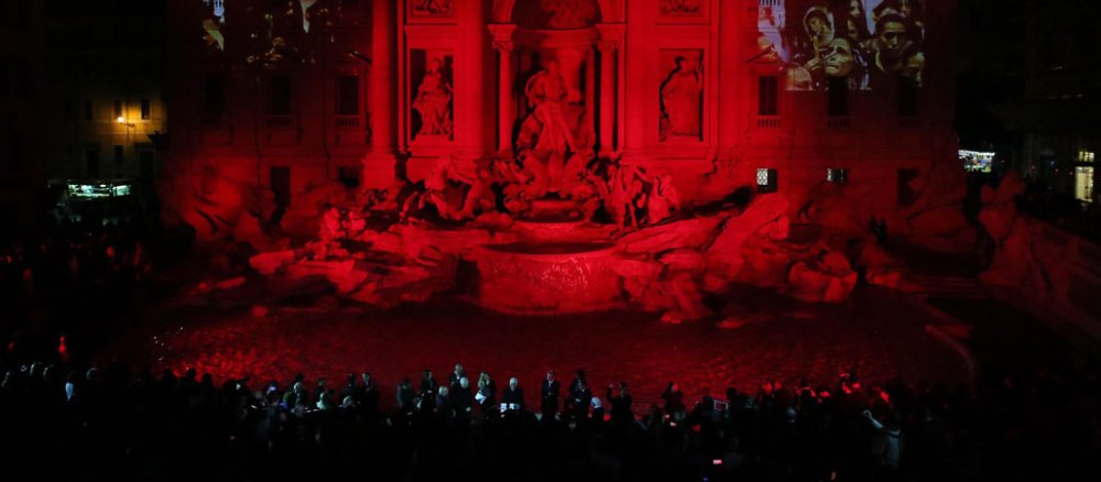 Der berühmte Trevi-Brunnen in Rom ist in rotes Licht getaucht.