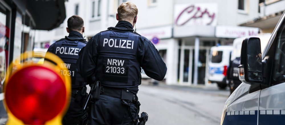 Polizisten stehen am frühen Morgen an einer Absperrung in der Innenstadt von Solingen.
