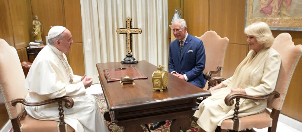 Papst Franziskus sitzt mit Prinz Charles und Camilla am Tisch