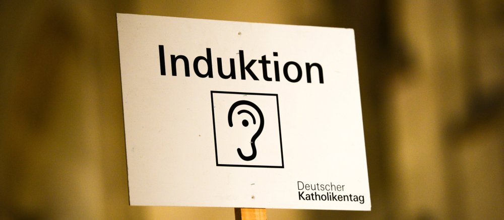 Schild mit Aufschrift "Induktion. Deutscher Katholikentag"