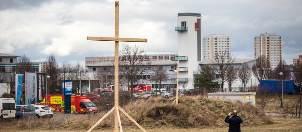 Eine Mann fotografiert am 06.03.2017 in Erfurt (Thüringen) ein großes Holzkreuz.