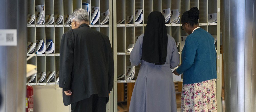 Participants in the World Synod, including women religious, check their mailboxes