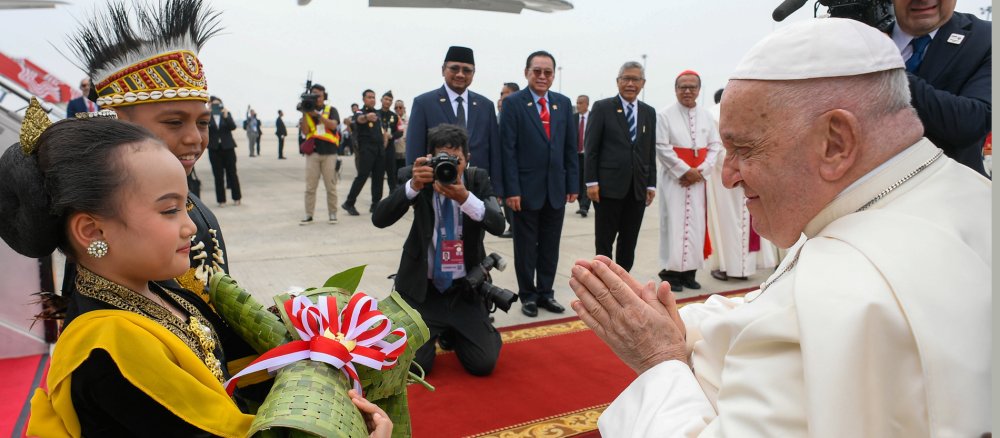 Pope Francis is greeted at the airport in Jakarta (Indonesia) by two children in traditional dress