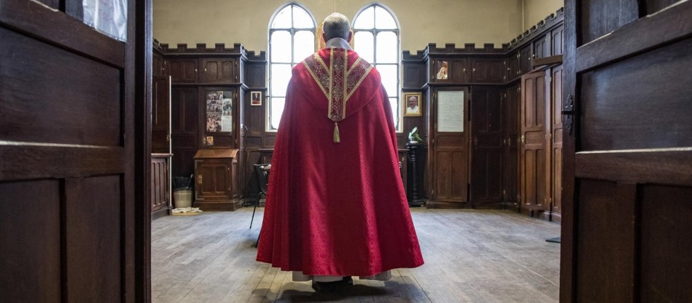 Rückansicht eines Priesters in einer Sakristei