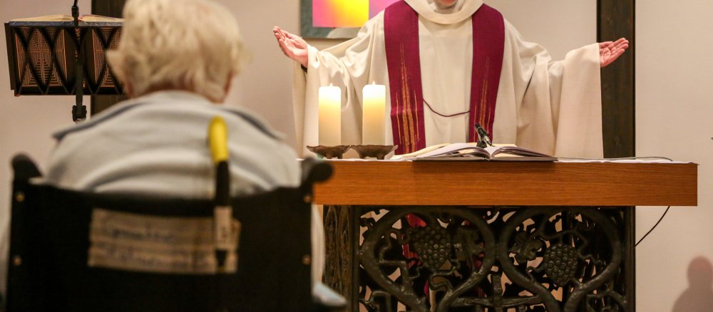 Eine Krankenhauspatientin sitzt im Rollstuhl bei einem Segnungsgottesdienst am 4. März 2015 in der Kapelle des Sankt Elisabeth-Krankenhauses in Bonn.