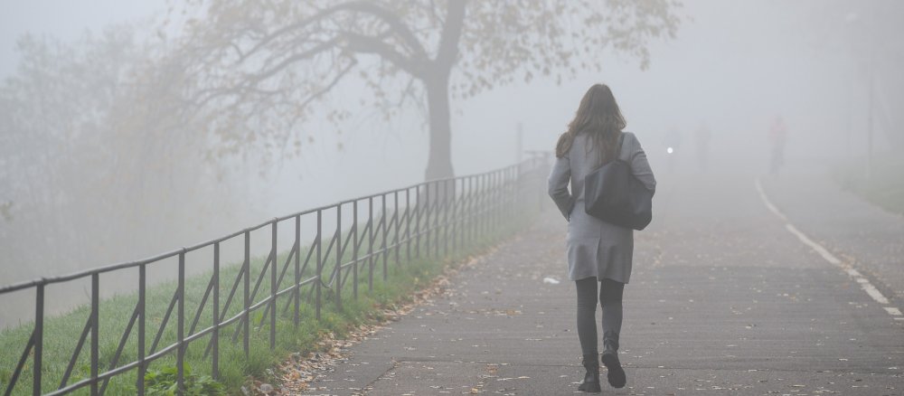 Eine Frau geht einen Gehweg entlang