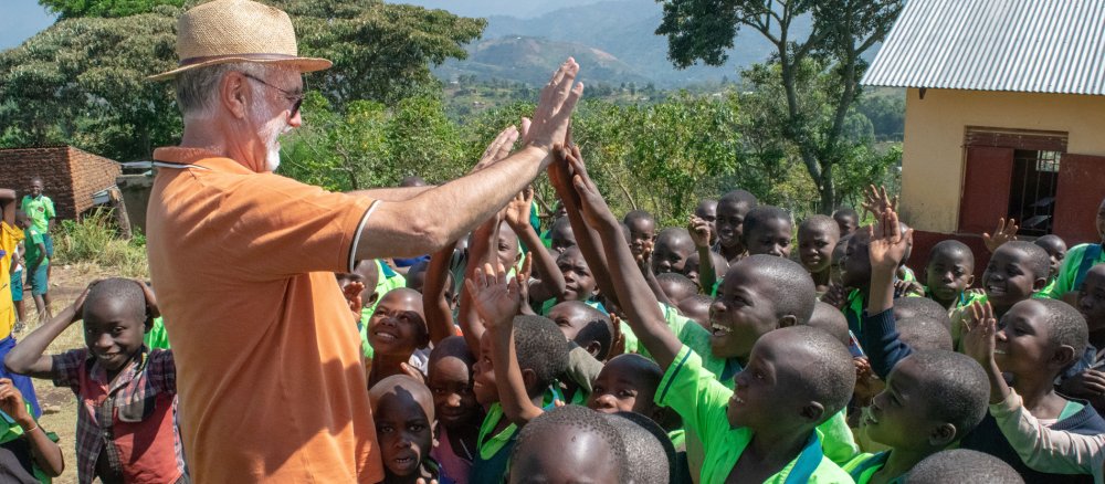 Junge Schüler aus Uganda klatschen den KAB-Diözesansekretär Peter Niedergesäss ab
