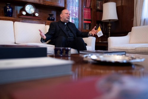 Erzbischof Franco Coppola sitzt in einem Büro und spricht bei einem Interview.