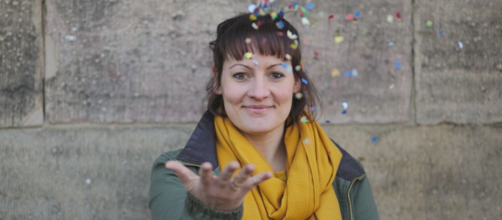 Bernadette Wahl ist für die City-Pastoral der Innenstadtpfarrei Fulda zuständig. Sie wirft auf dem Bild buntes Konfetti in die Luft.