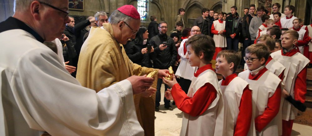 Bischof Rudolf Voderholzer verteilt Osterhasen an die Regensburger Domspatzen.
