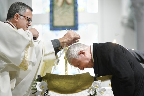 Ein Priester tauft einen Mann in der Osternacht am 15. April 2017 in der Kirche Sankt Honore d'Eylau in Paris.