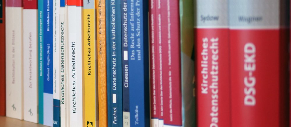 Ein Bücherregal mit Literatur zum kirchlichen Datenschutzrecht und Arbeitsrecht