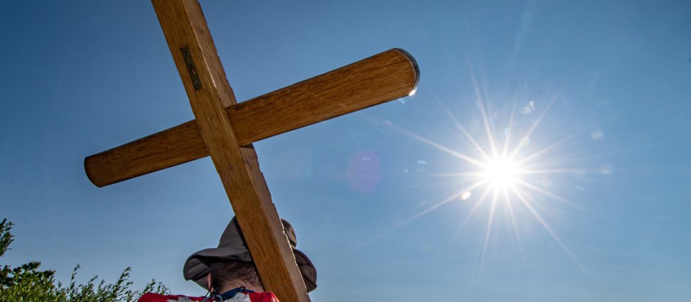 Ein Wallfahrer trägt ein Holzkreuz
