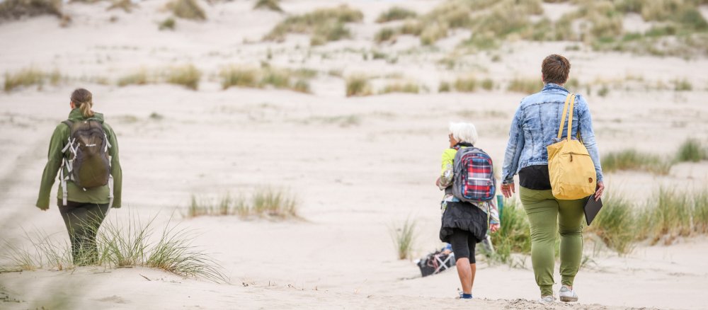 Drei Frauen wandern durch die Dünen auf der Insel Norderney