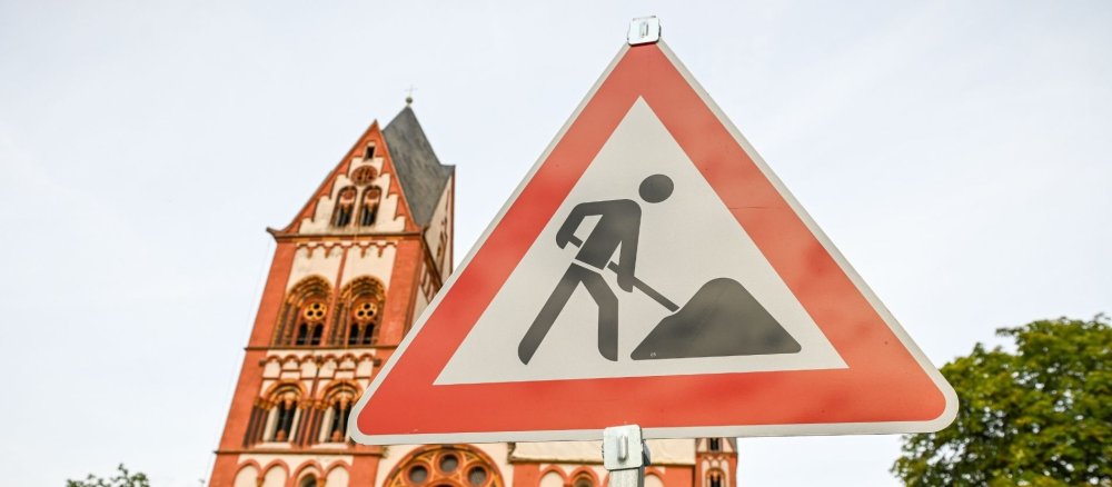 Ein Baustellenschild, im Hintergrund der Limburger Dom