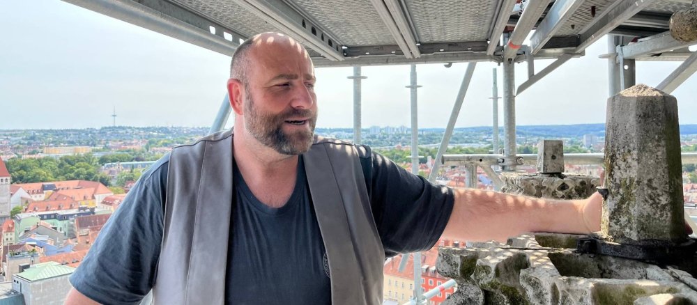Christian Pilz erläutert in luftiger Höhe, wie die Steinmetze die kunstvollen Verzierungen der Domtürme restaurieren und pflegen.
