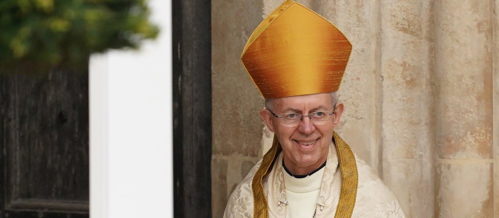 Justin Welby with mitre in front of Westminster Abbey