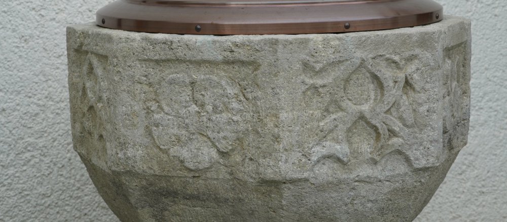 In die Außenwand des Taufsteins von Schloss Lenzburg sind Rosen und gotische Verzierungen eingemeißelt.