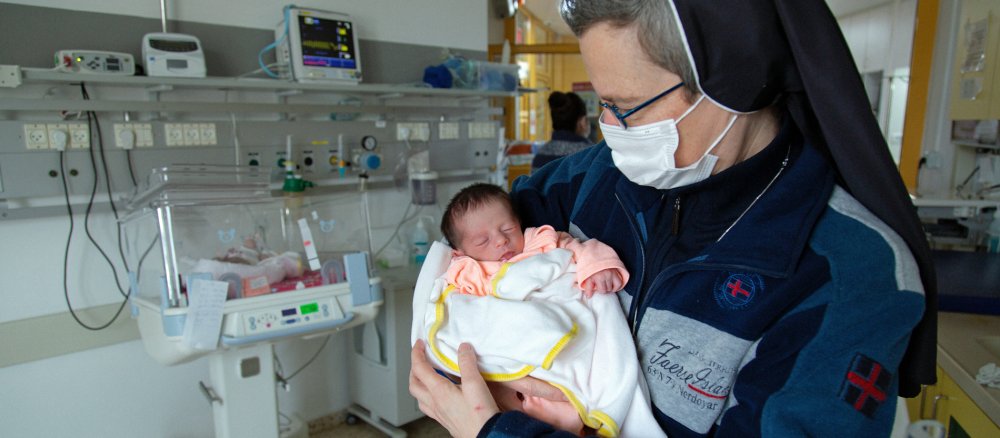 Eine Ordensschwester hält ein Baby