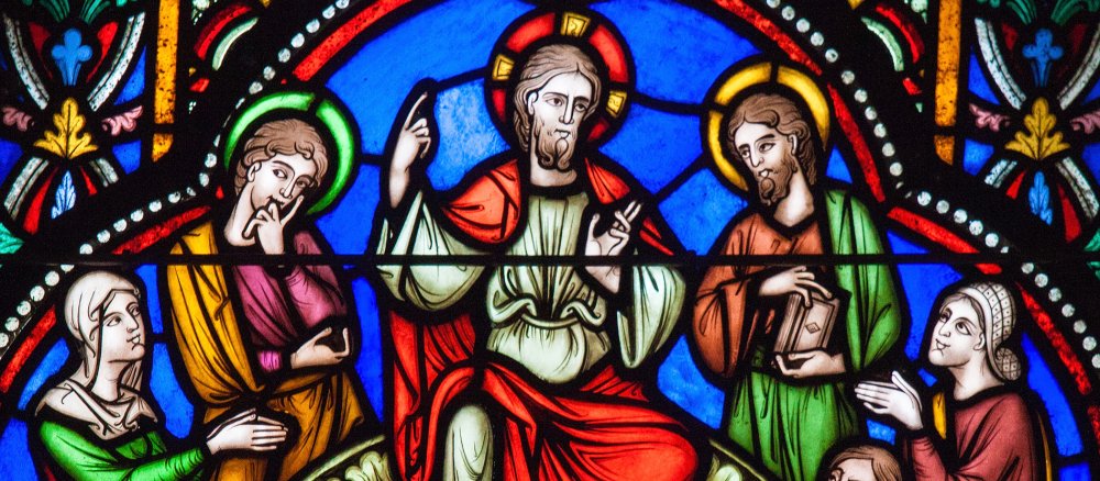 Ein Bleiglasfenster zeigt Jesus bei der Bergpredigt.