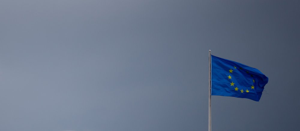 Dunkle Wolken sind über dem Reichstag und der Europa-Flagge in Berlin zu sehen.