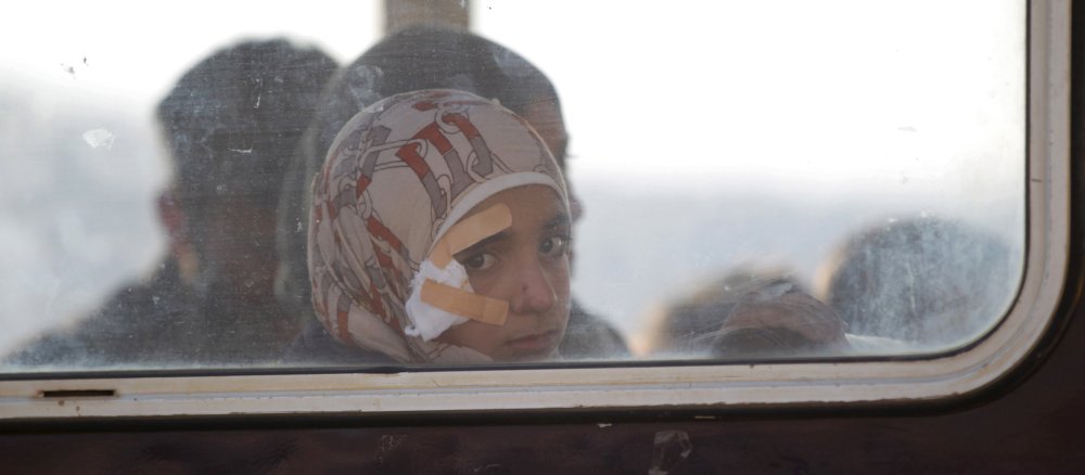 Ein verwundetes Syrisches Mädchen sitzt am Fenster in einem Bus mit Flüchtlingen.