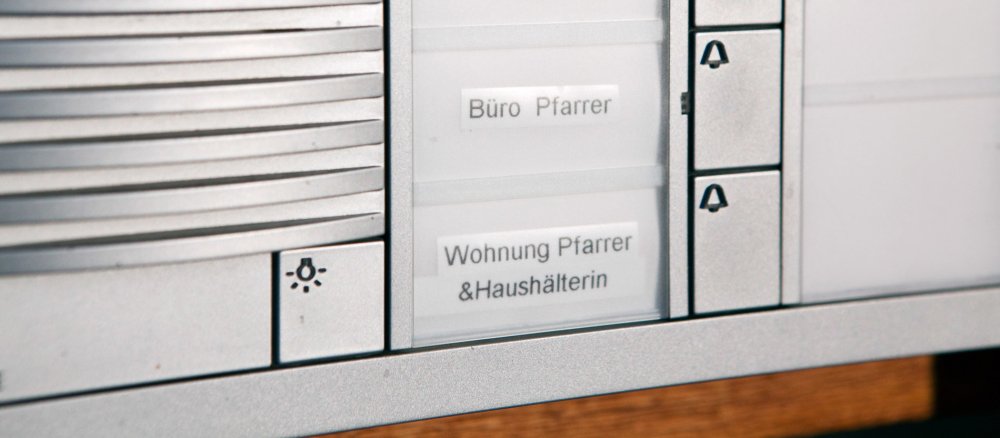 Ein Klingelschild mit der Aufschrift Wohnung Pfarrer und Haushaelterin