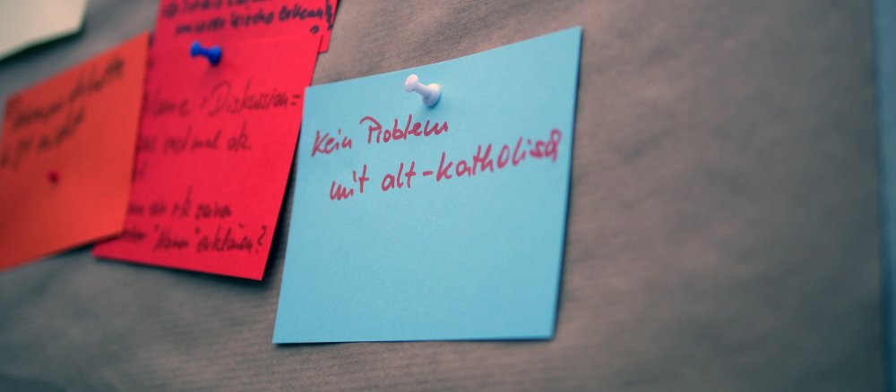 Karte an einer Pinnwand mit der Aufschrift "kein Problem mit alt-katholisch"