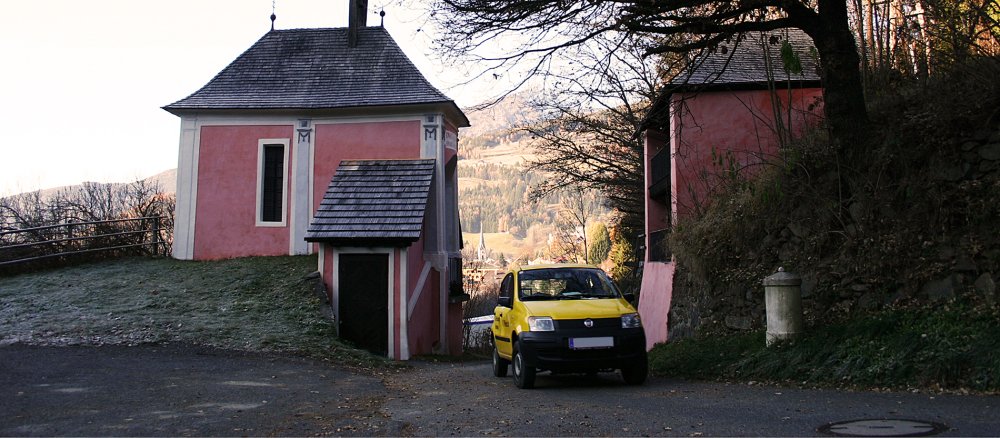 Durch die Kreuzbichlkapelle im österreichischen Gmünd verläuft eine Straße, auf der ein Auto fährt.