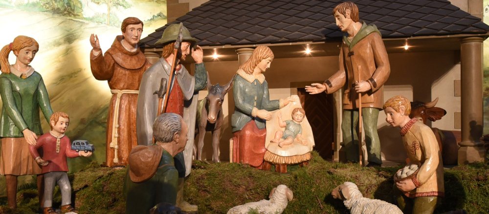 Ganz viele unterschiedliche Menschen kommen zur Weihnachtskrippe.