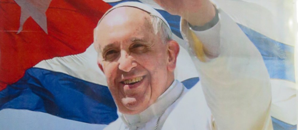 Papst Franziskus vor kubanischer Flagge auf einem Plakat