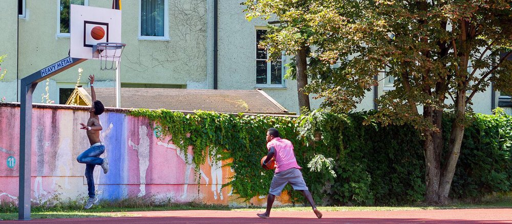 Zwei junge Flüchtlinge trainieren Basketball.