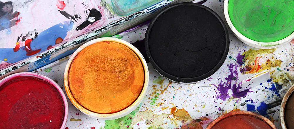 Ein Tuschkasten mit den Farben rot, gelb, schwarz und grün.