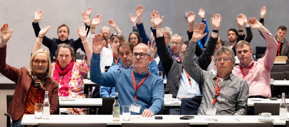 Mitglieder der GKP stimmen bei der Mitgliederversammlung durch Handzeichen ab