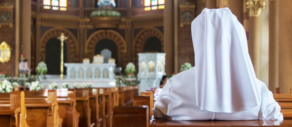 Eine Nonne sitzt in der Kirche und betet